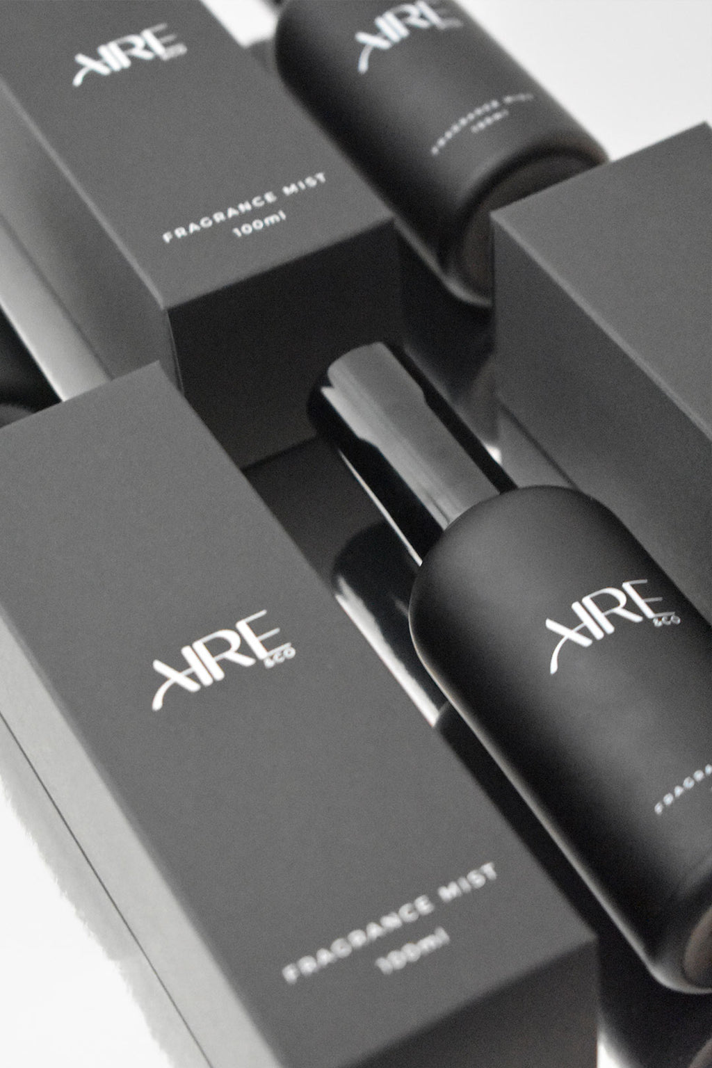 Aire & Co home fragrance mist bottles and packaging on a reflective surface