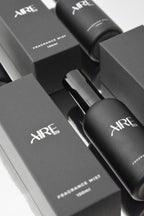 Aire & Co home fragrance mist bottles and packaging on a reflective surface