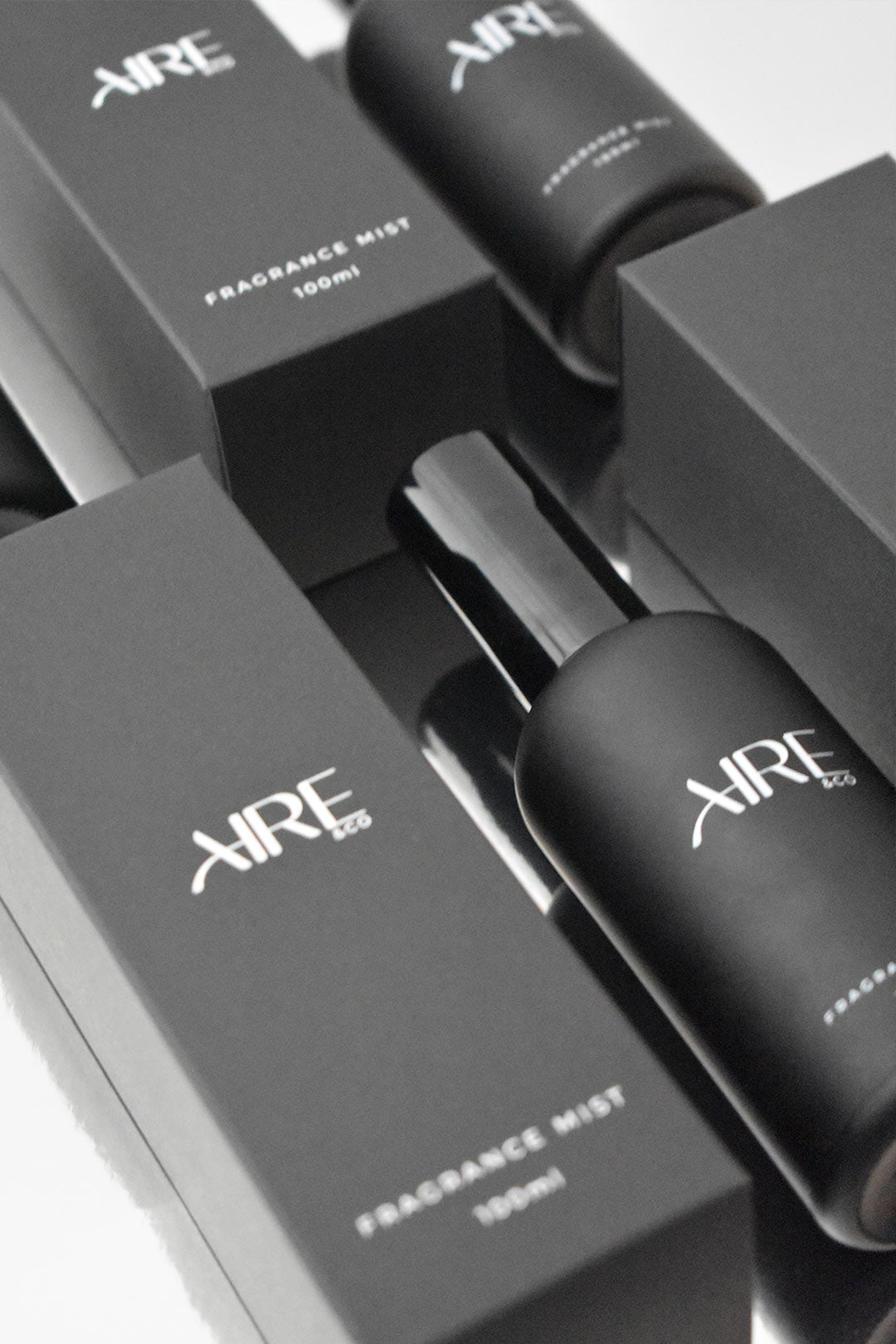 Aire & Co home fragrance mist bottles and packaging on a reflective surface