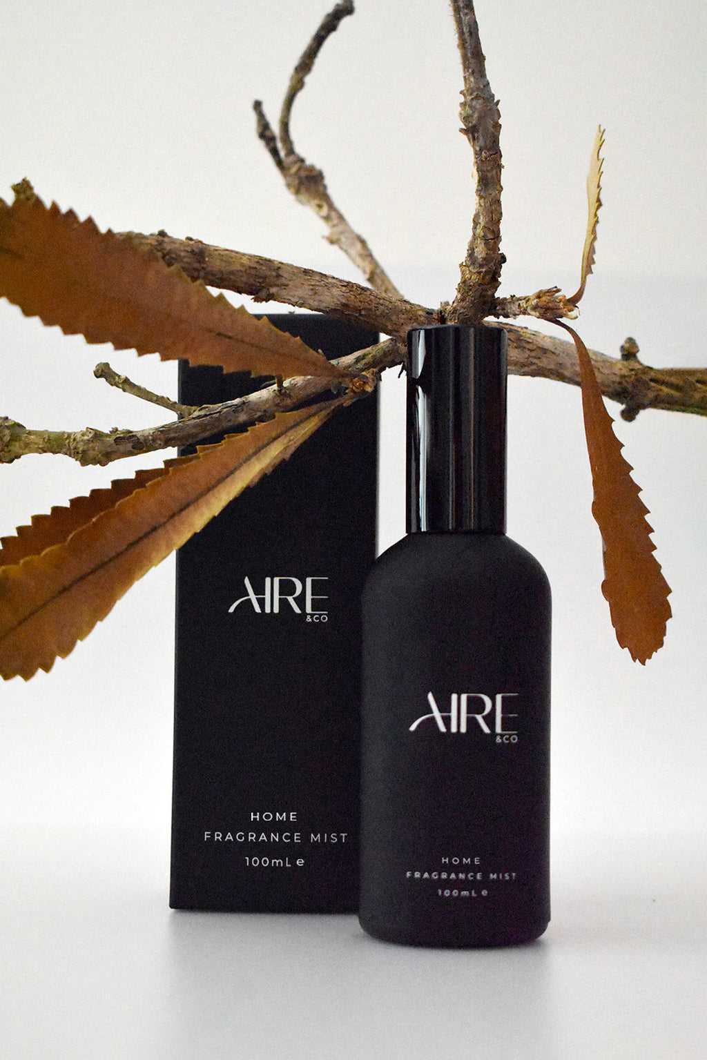 Essence Aire & Co home fragrance mist bottle and packaging with branches and leaves on a white background