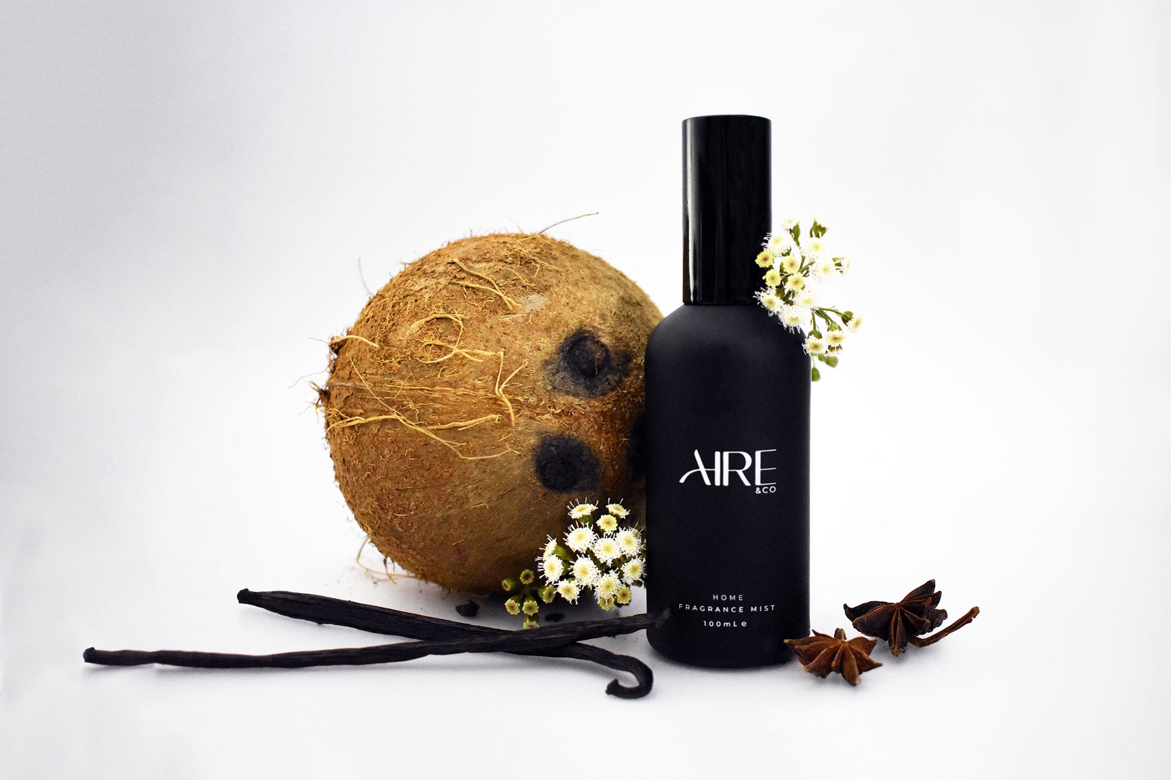 Essence Aire & Co home fragrance mist bottle with a coconut, vanilla beans, and star anise on a white background