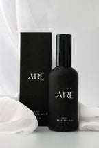 Linen Aire & Co home fragrance mist bottle and packaging on white fabric on a white background
