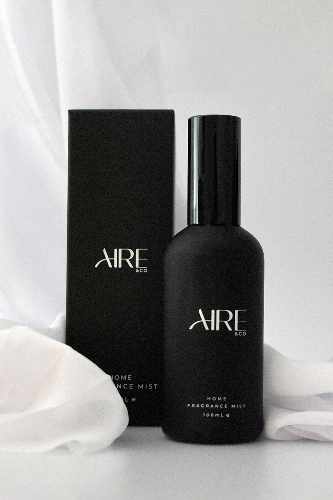 Linen Aire & Co home fragrance mist bottle and packaging on white fabric on a white background