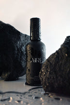 Ocean home fragrance mist bottle by Aire & Co on coastal rocks with water