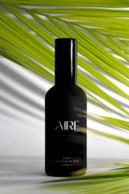 Palm Aire & Co home fragrance mist bottle with palm leaves in the background